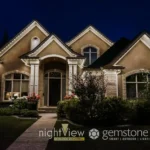 Permanent Christmas lighting installed along the roofline of a home, creating a soft, warm glow across the exterior at night.