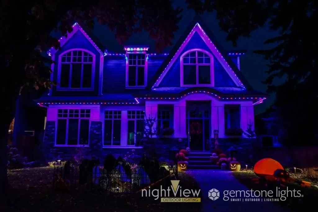 Permanent holiday lighting creates a vibrant purple glow and Halloween-inspired effects across the exterior of a home at night.
